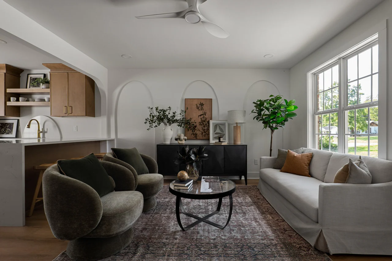 Living room with arched wall details, sofa and swivel chairs