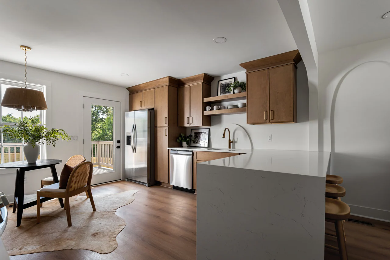 Kitchen with dining nook, wood cabinetry and waterfall peninsula