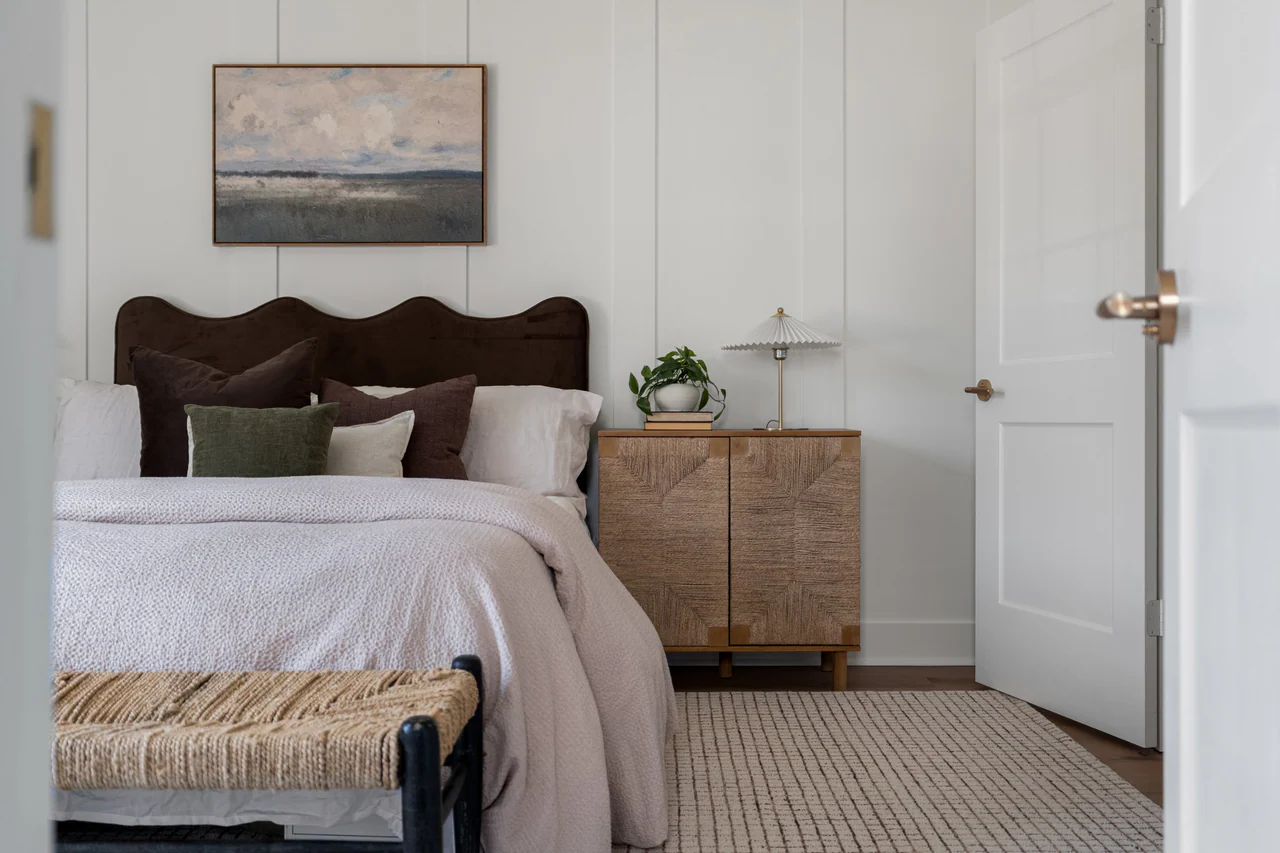 Bedroom with upholstered headboard and woven cabinet