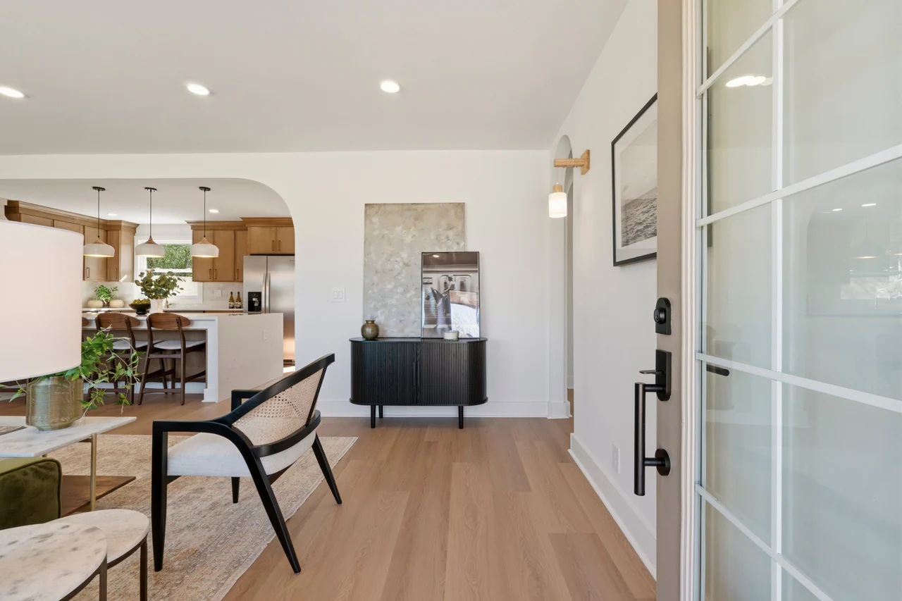 Entry looking past a black sideboard and arched opening to the kitchen