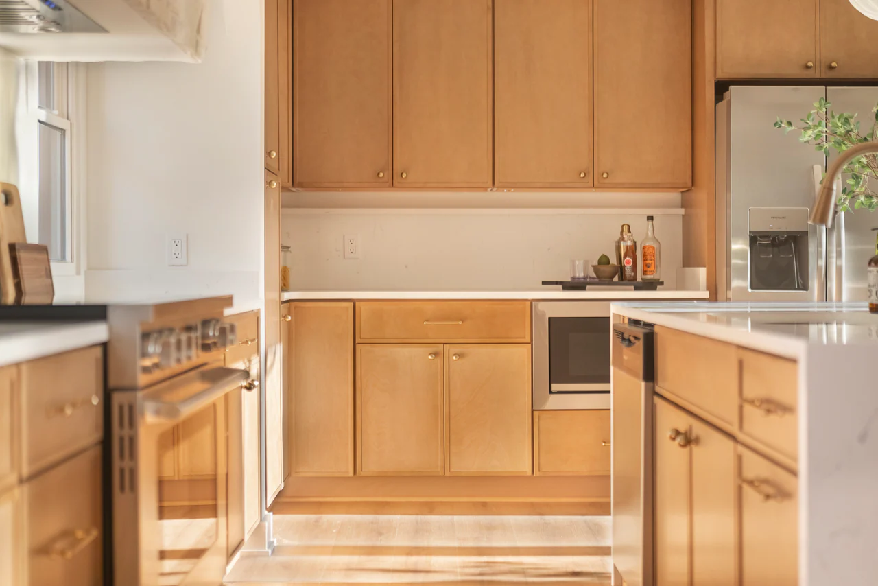 Wood cabinetry and stainless appliances in afternoon light